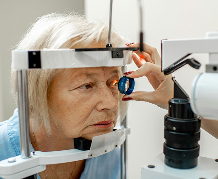 Older woman undergoing an eye exam with equipment related to LASIK eye surgery and vision health evaluation.