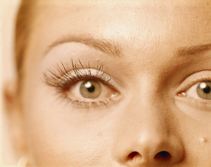 Close-up of a woman's face focusing on eyes and skin, related to stirrup pants fashion trends from youth.