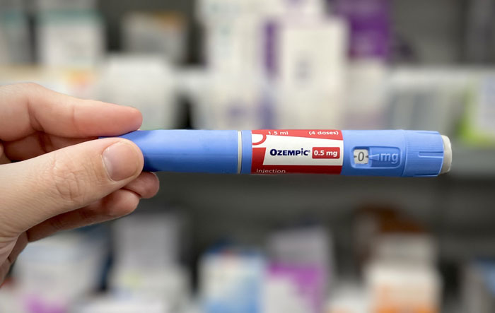 Hand holding an Ozempic injection pen with 0.5 mg dosage, a popular diet medicine discussed by experts. Hand holding an Ozempic injection pen with 0.5 mg dosage, a popular diet medicine discussed by experts.