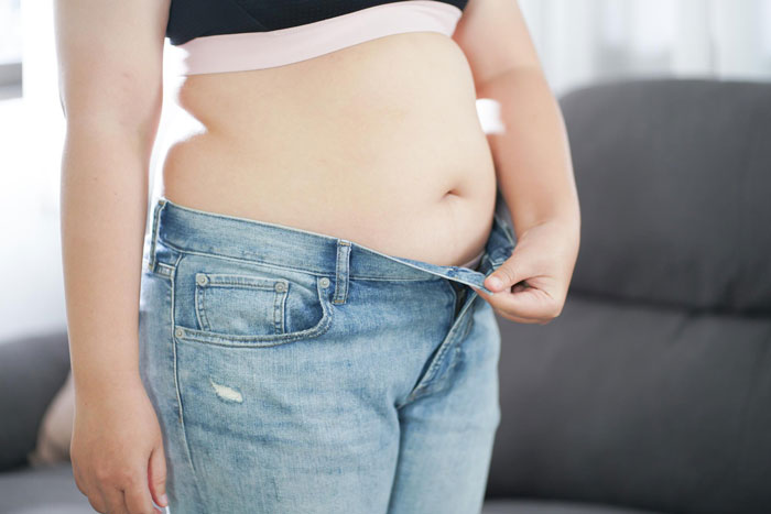 Person showing loose jeans around the waist, illustrating the effects of Ozempic diet medicine on weight loss. Person showing loose jeans around the waist, illustrating the effects of Ozempic diet medicine on weight loss.