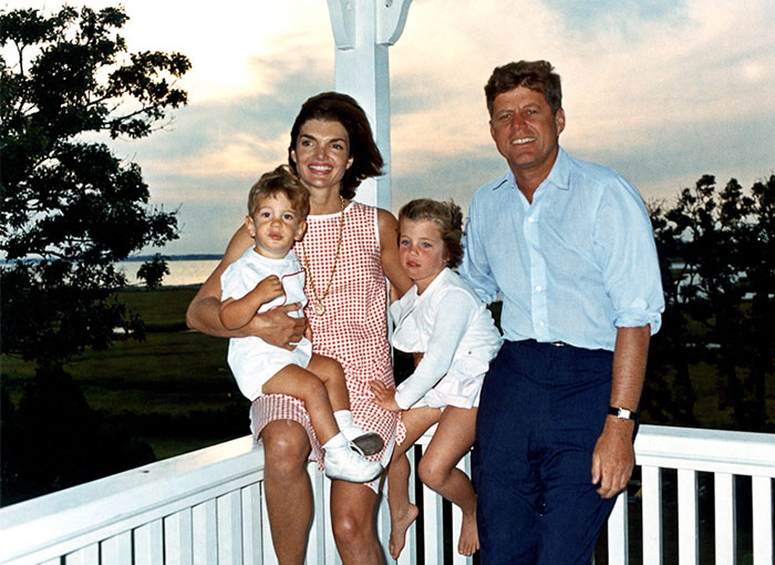 John F. Kennedy with family outdoors at sunset, representing famous celebrities remembered differently after passing.