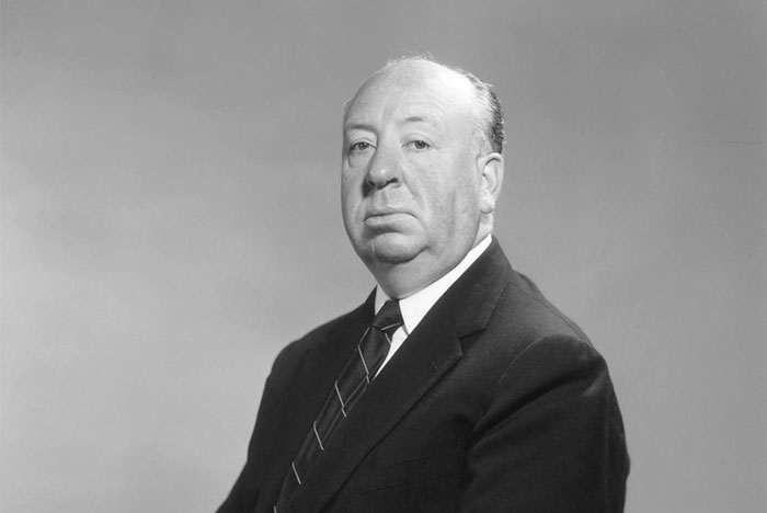 Black and white portrait of a serious man in a suit, representing Steve Jobs among celebrities praised after passing.