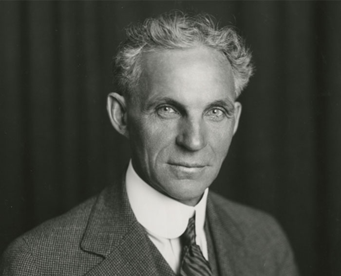 Black and white portrait of a serious man in a suit, representing celebrities like Steve Jobs praised after passing.