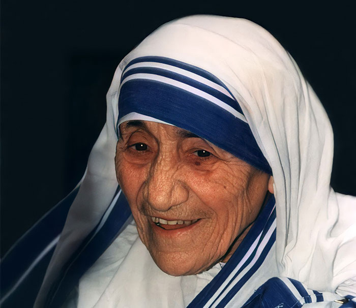 Portrait of an elderly woman in a white and blue headscarf, symbolizing saints praised after passing like Steve Jobs.