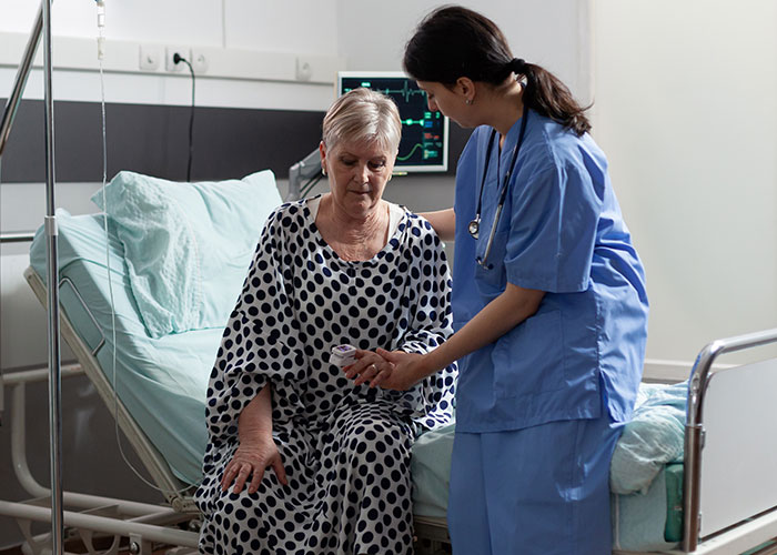 Nurse comforting elderly patient in hospital room, illustrating chilling final words doctors and nurses often hear.