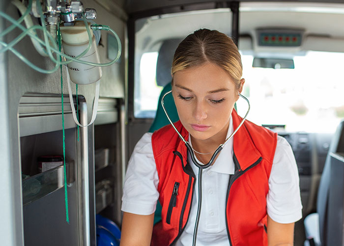 Female nurse in ambulance wearing stethoscope, reflecting on chilling final words from dying patients in a medical emergency.