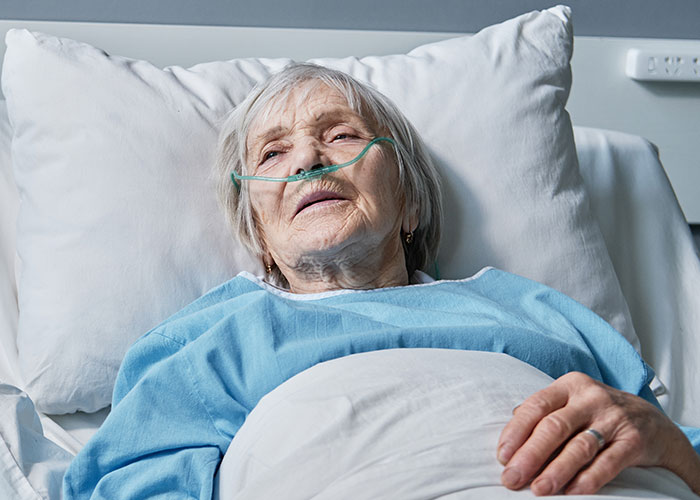 Elderly woman in hospital bed with nasal oxygen, reflecting chilling final words doctors and nurses heard from dying patients.