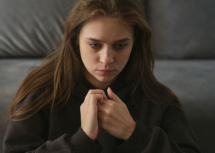 Young woman looking distressed and contemplative, reflecting on chilling final words doctors and nurses heard from patients.