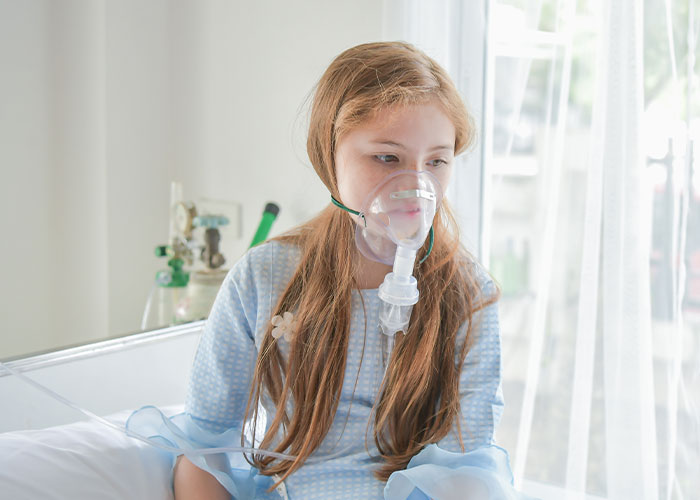 Young patient wearing oxygen mask in hospital bed, highlighting chilling final words doctors and nurses heard from patients