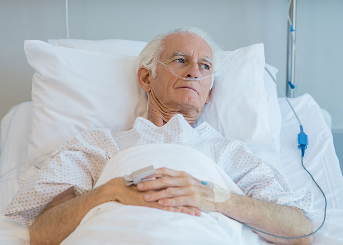 Elderly man with oxygen tube lying in hospital bed, reflecting the chilling final words of dying patients heard by doctors and nurses.