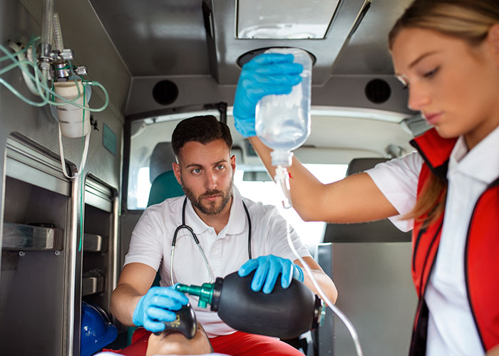 Paramedics providing emergency care inside an ambulance highlighting patient’s lie risks in critical medical situations.