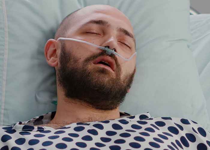 Patient in hospital bed with oxygen tube, highlighting dangers when a patient's lie nearly risks their life.
