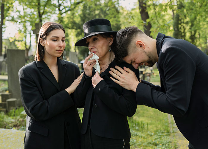 A grieving family at a cemetery, illustrating the risks when a patient’s lie nearly costs their life.