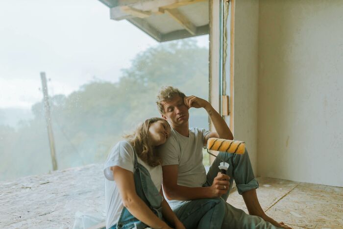 Couple resting during home renovation, illustrating things folks only romanticize without real experience.