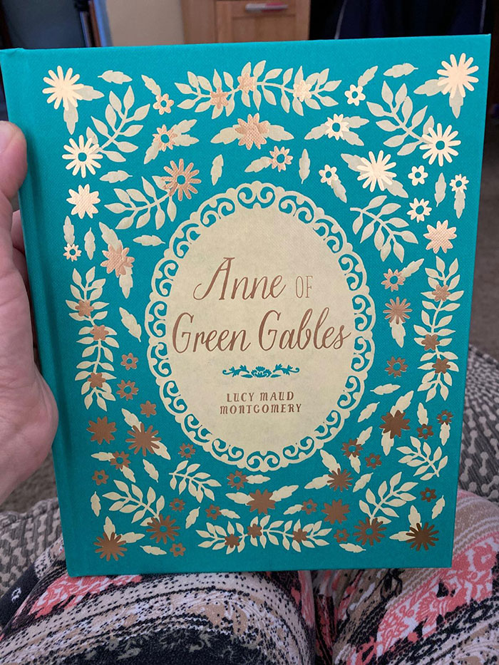 Hand holding a decorative edition of Anne of Green Gables, one of the excellent books recommended by readers online.