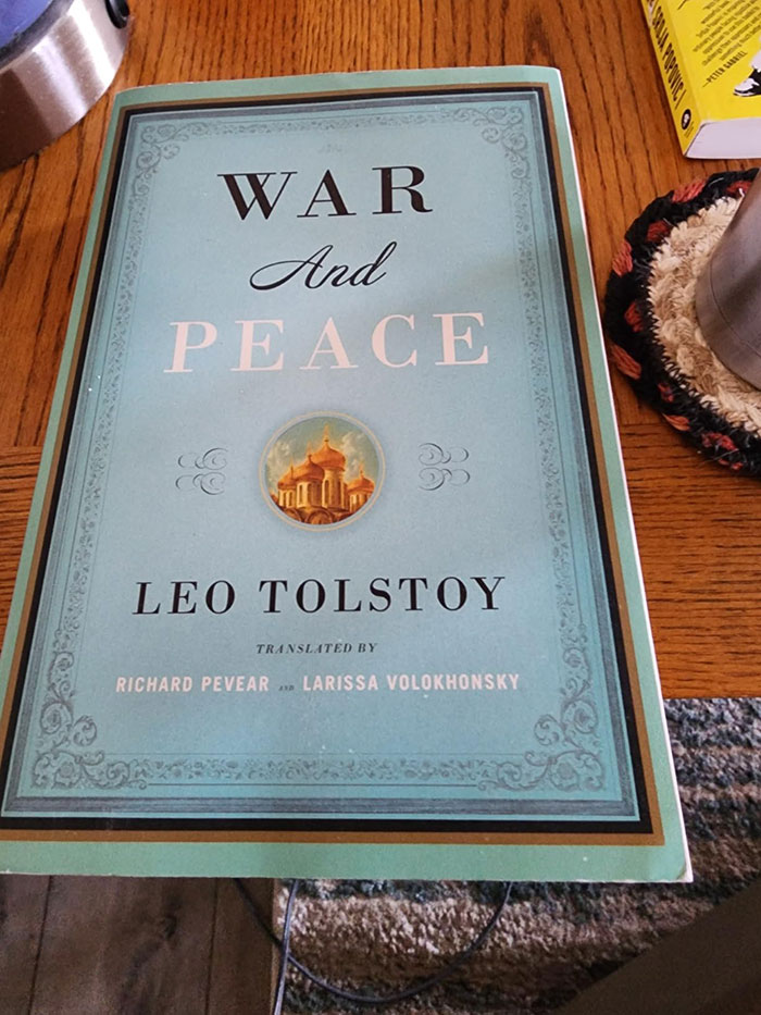 War and Peace book by Leo Tolstoy on a wooden table, featured among excellent books recommended by readers online.