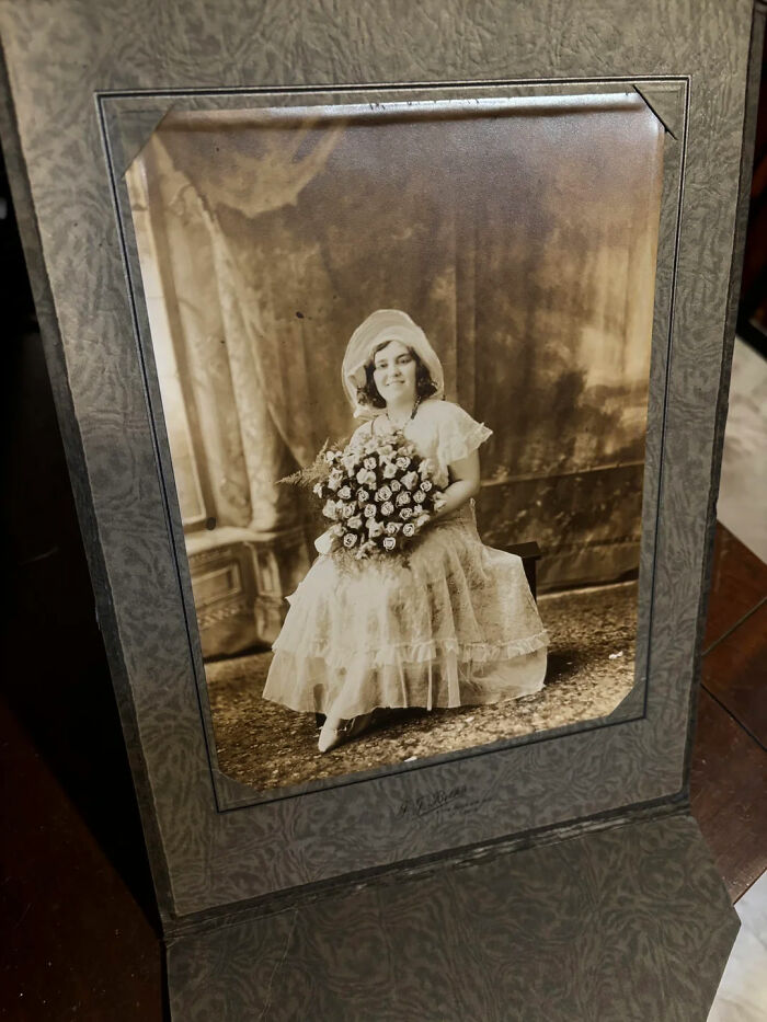 Vintage portrait photo of a woman in a dress holding flowers, part of people share found photos collection.