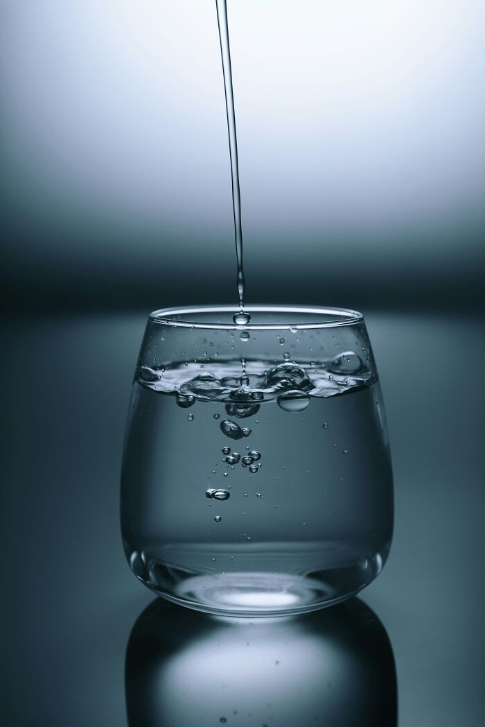 Close-up of water pouring into a glass with bubbles forming, illustrating simple life hacks and everyday common knowledge.
