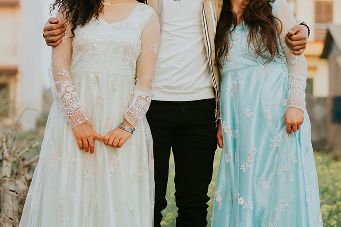 Three people standing close together outdoors, representing former cult members sharing experiences.