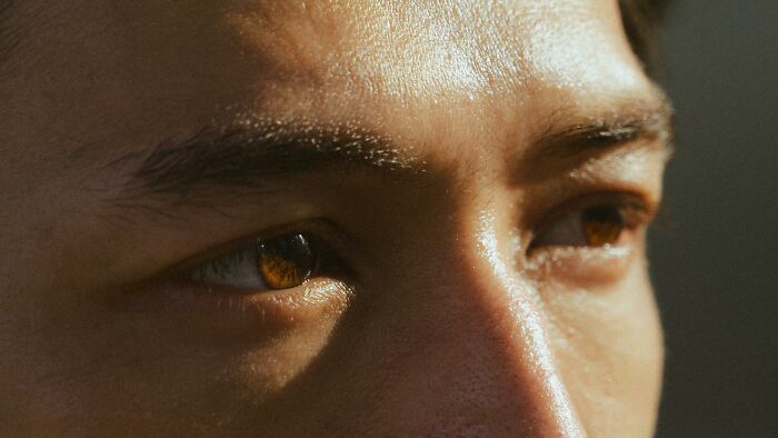 Close-up of a person's eyes and skin texture, highlighting details relevant to plastic surgeons and cosmetic procedures.