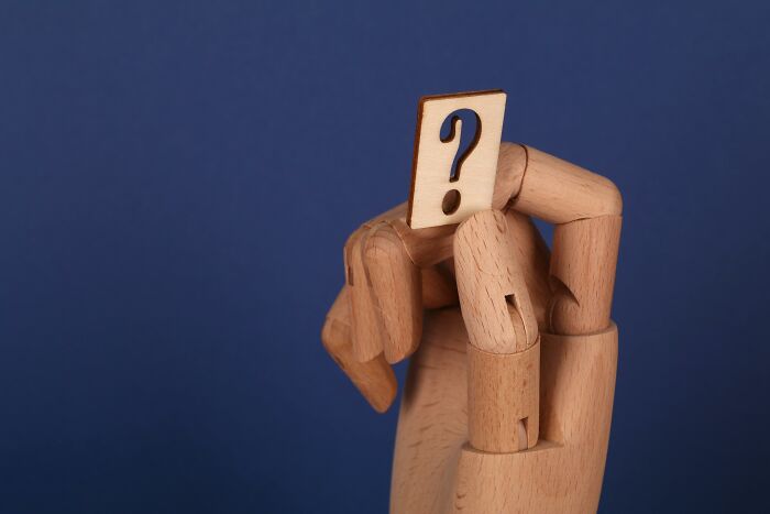 Wooden mannequin holding a block with a question mark, symbolizing idiom matching and definition challenge quiz. Wooden mannequin holding a block with a question mark, symbolizing idiom matching and definition challenge quiz.