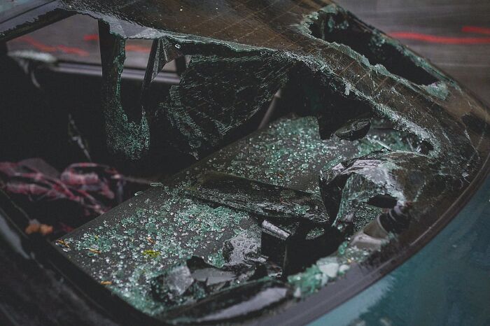 Broken car window with shattered glass inside, illustrating shocking and surreal experiences people have lived through.