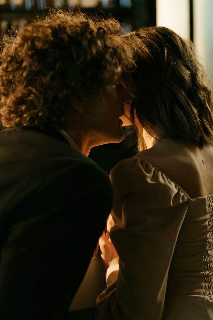 Man whispering closely to a woman who looks uncomfortable, highlighting moments women felt instantly unsafe with a man.