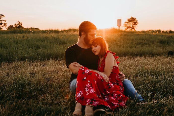Couple sitting in a field at sunset, illustrating employees reflecting on strange and dumb things heard from recruiters.