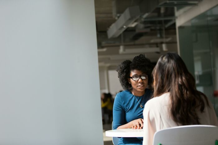 Two women having a serious conversation at a table, illustrating harsh life advice related to when life gives you lemons.