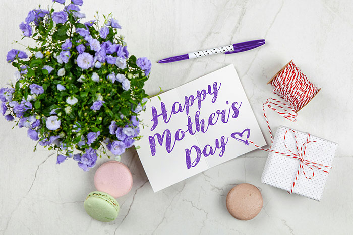 Mother’s Day card with flowers, gift box, and macarons symbolizing dog mom DIL seeking equal treatment from MIL. Mother’s Day card with flowers, gift box, and macarons symbolizing dog mom DIL seeking equal treatment from MIL.