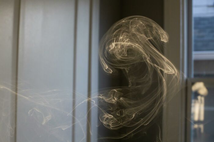 Swirling smoke patterns inside a dimly lit room illustrating the placebo effect in real life examples.