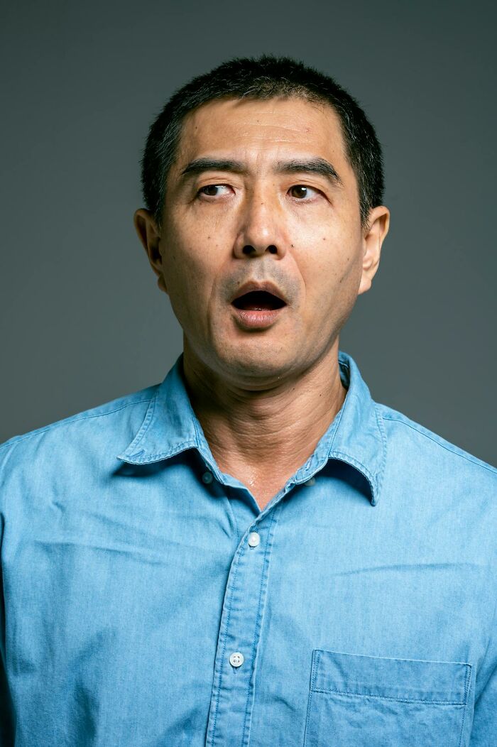 Middle-aged man in a blue shirt with an open mouth expressing surprise, related to questions women ask men.