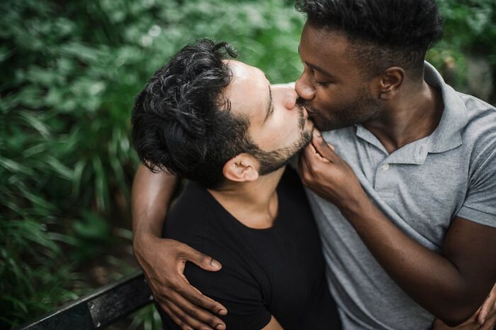Two men sharing a tender kiss outdoors, symbolizing relationships and the reasons people called off their wedding.