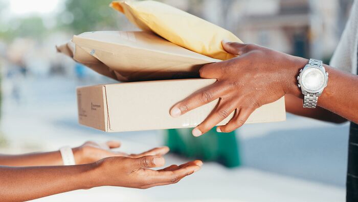 Hands exchanging packages outdoors, illustrating body changes that indicate you are clearly getting older.