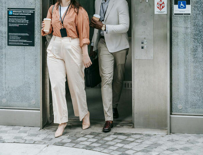 A woman and a man exiting an elevator, representing moments when women felt instantly unsafe with a man.