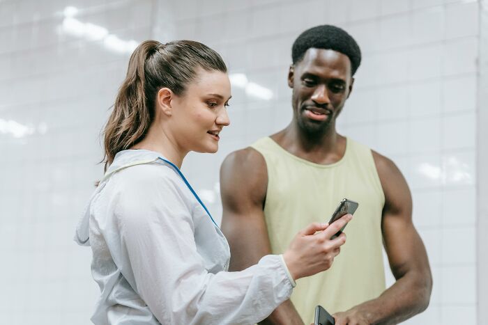 Two people sharing life hacks on a smartphone, illustrating useful tips that deserve to be common knowledge.