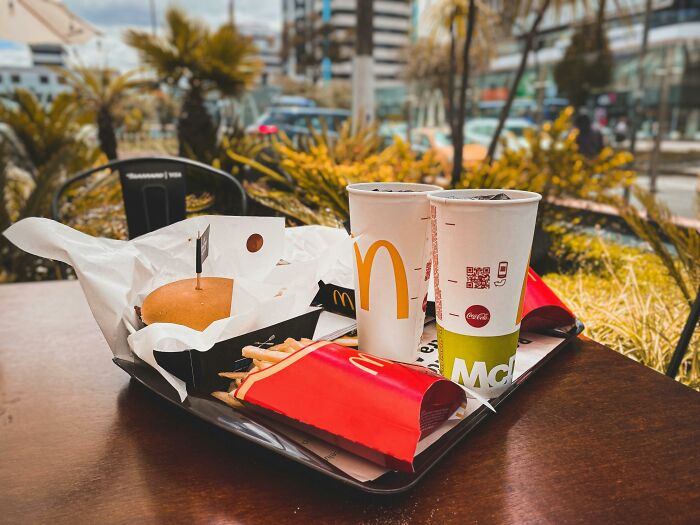 Tray with french fries, burger, and two drinks including Diet Coke, highlighting french fries and Diet Coke for migraine relief.