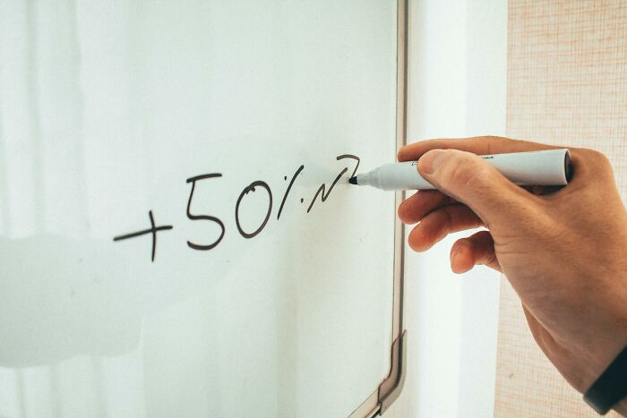 Person writing a 50 percent increase on a whiteboard illustrating appalling facts people unaware of trends.