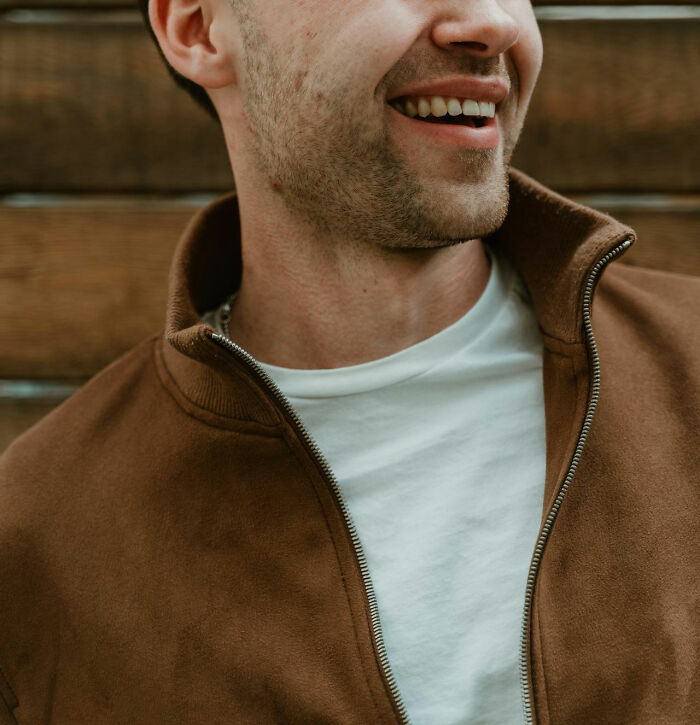 Close-up of a man smiling, illustrating the contrast of moments women felt instantly unsafe with a man who seemed safe.