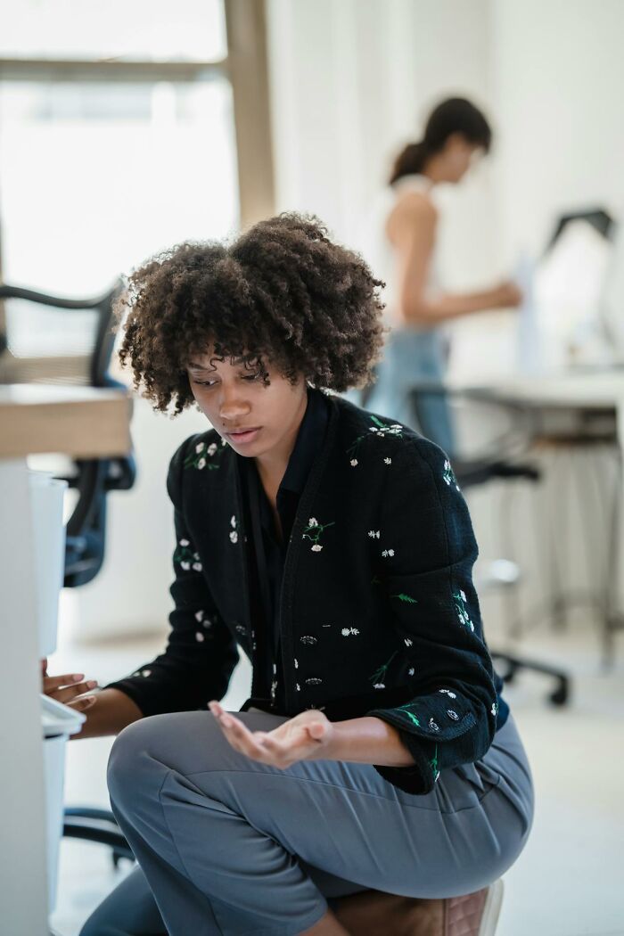 Woman looking concerned and uneasy while sitting indoors, reflecting feelings of safety and moments of feeling unsafe with a man.
