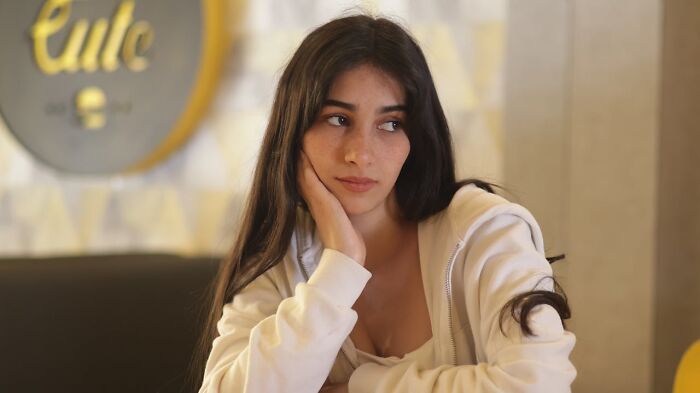 Young woman sitting thoughtfully in a casual setting, reflecting on boomer opinions people actually agree with.