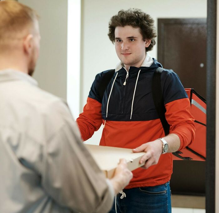 Young delivery person handing a package to a customer, showcasing one of the most shocking real-life experiences people have lived through.