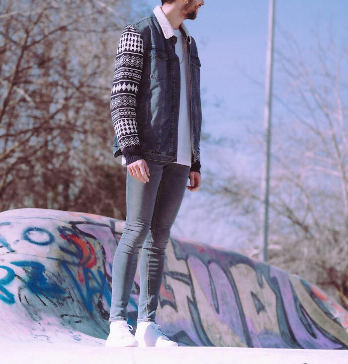 Young man standing by a colorful graffiti wall outdoors, reflecting an urban vibe related to women asking questions to men.