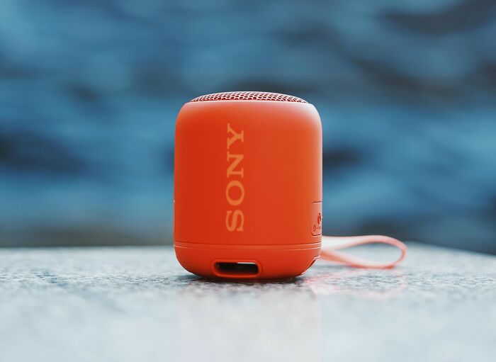 Compact orange Sony speaker on a smooth surface representing a tiny thing that made the trip better.