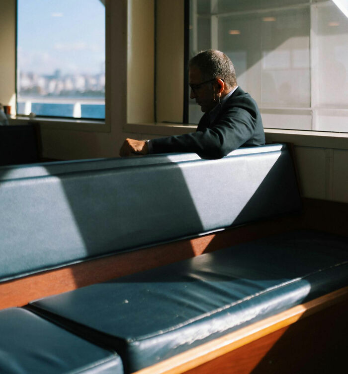 Man sitting alone on a bench by window, conveying the feeling of instantly unsafe moments shared by women around men.