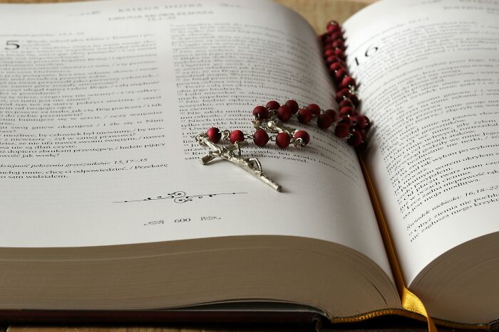 Open book with a rosary placed inside, symbolizing one of the biggest mistakes that changed the course of history.