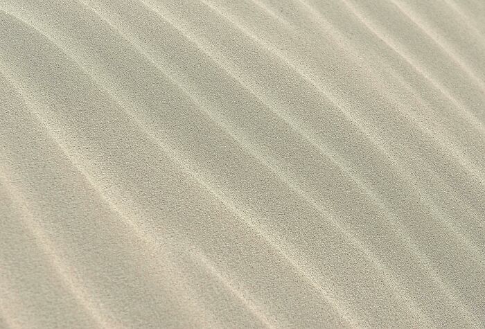 Close-up of sand with natural ridges and patterns, illustrating simple life hacks for everyday knowledge and easy solutions.