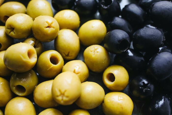 Close-up of yellow and black olives, illustrating common foods that go bad more quickly than we might think.