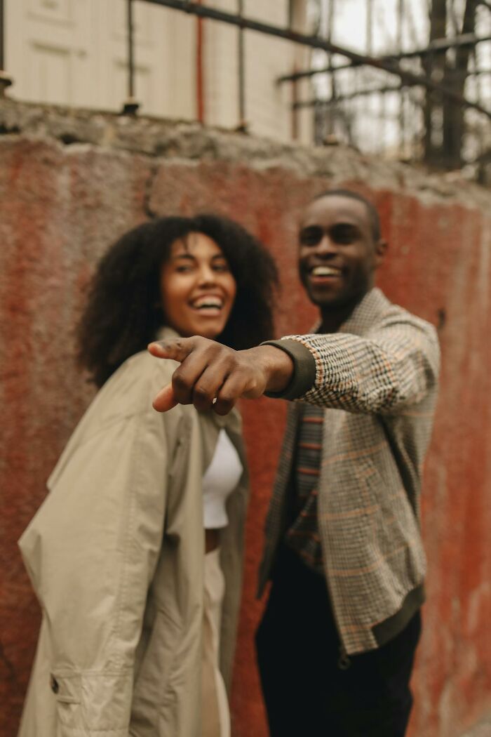 Two young people smiling and pointing, illustrating themes related to middle class challenges for Gen Z.
