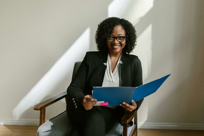 Woman in business attire reading documents, representing employees sharing experiences with strange recruiter encounters.